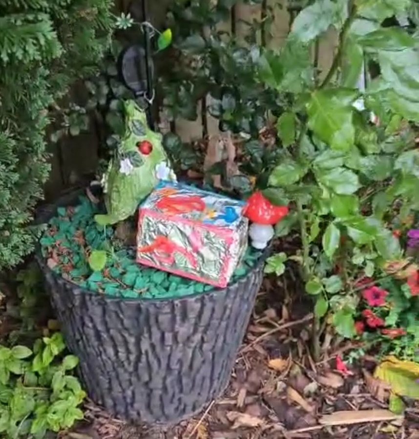 The finished box, wrapped in foil and painted, in the fairy garden